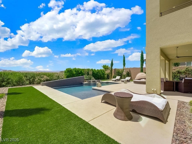 view of swimming pool with ceiling fan and a patio