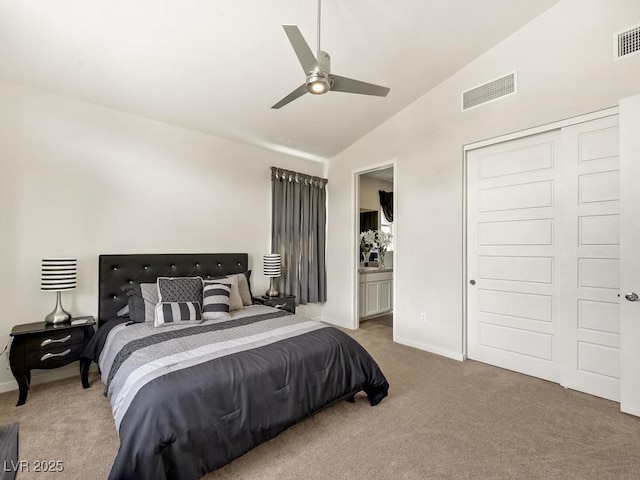 carpeted bedroom with ceiling fan, connected bathroom, vaulted ceiling, and a closet