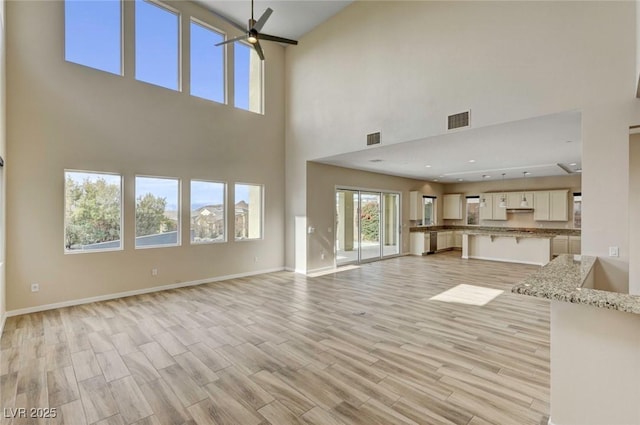 unfurnished living room with ceiling fan and light hardwood / wood-style floors