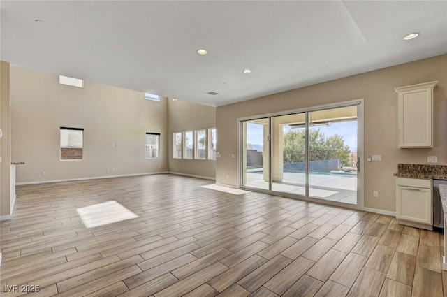 unfurnished living room with plenty of natural light and light hardwood / wood-style floors