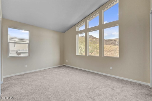 carpeted spare room with a mountain view and vaulted ceiling