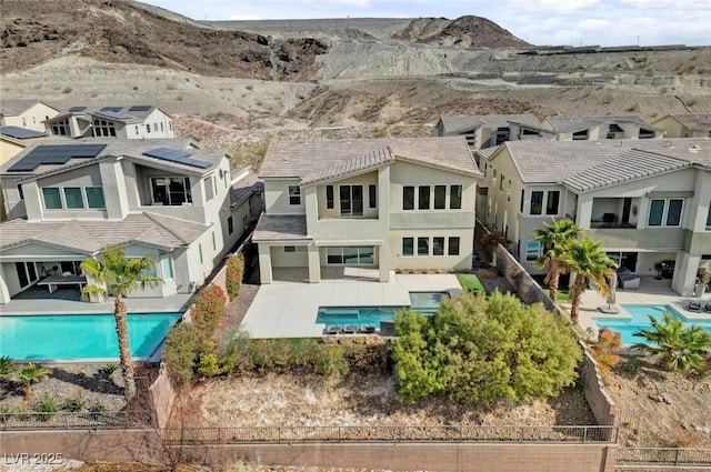 back of property featuring a mountain view and a fenced in pool