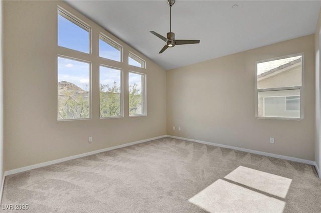 carpeted empty room featuring vaulted ceiling and ceiling fan