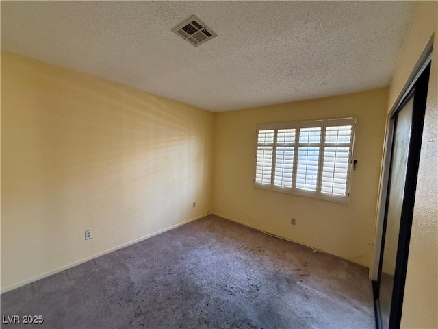 carpeted spare room with a textured ceiling