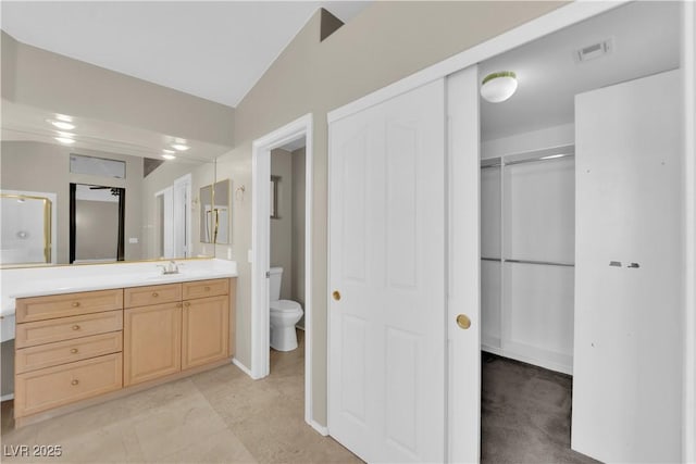 bathroom featuring lofted ceiling, vanity, and toilet