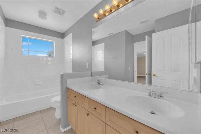 full bathroom featuring vanity, tiled shower / bath, tile patterned floors, and toilet