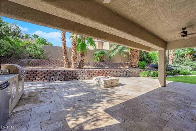 view of patio with an outdoor kitchen, a grill, ceiling fan, and a fire pit