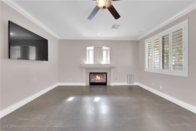 unfurnished living room with a tiled fireplace, ornamental molding, dark wood-type flooring, and ceiling fan