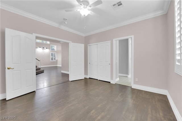 unfurnished bedroom with crown molding and dark wood-type flooring