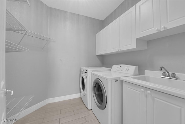 washroom with cabinets, sink, and washing machine and clothes dryer