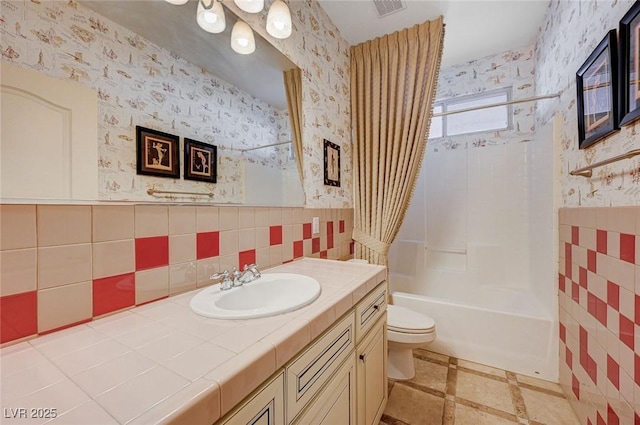 full bathroom with vanity, toilet, shower / tub combo, and tile walls