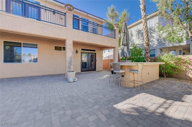 view of patio featuring a balcony and exterior bar