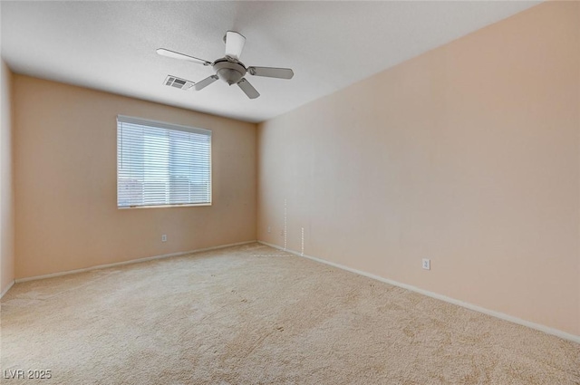 spare room with ceiling fan and light colored carpet