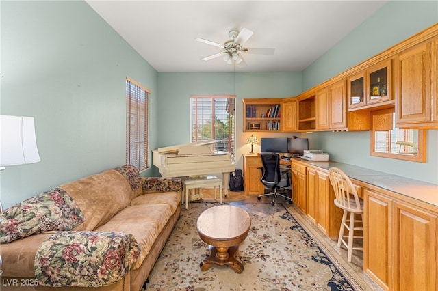 home office featuring ceiling fan and built in desk