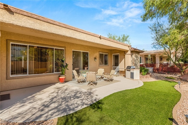 rear view of property with a yard and a patio