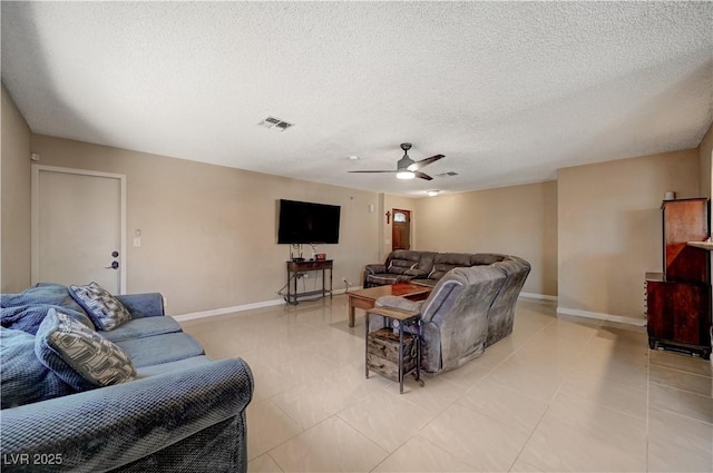 living room with ceiling fan, a textured ceiling, and light tile patterned floors