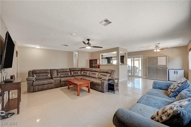 living room with a textured ceiling and ceiling fan