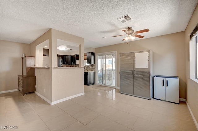 kitchen featuring light tile patterned flooring, backsplash, ceiling fan, kitchen peninsula, and a textured ceiling