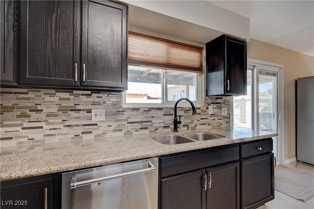 kitchen with dishwasher, light stone countertops, sink, and decorative backsplash