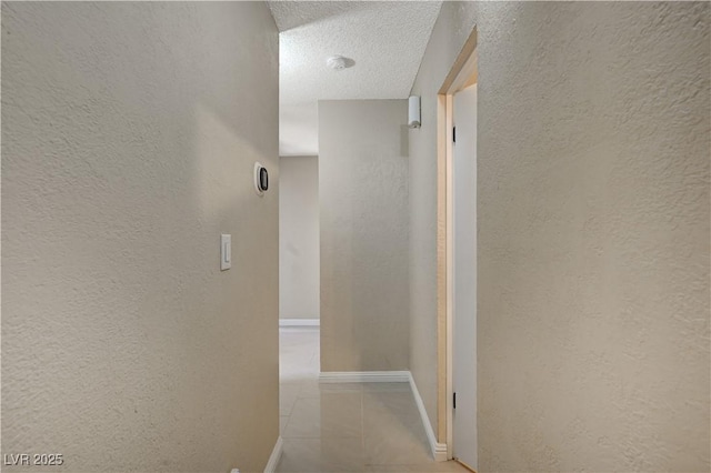 hall featuring a textured ceiling