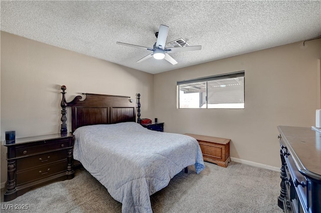 carpeted bedroom with ceiling fan and a textured ceiling