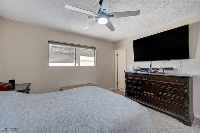 carpeted bedroom featuring ceiling fan and a textured ceiling