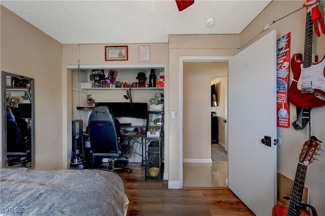 bedroom featuring wood-type flooring and a textured ceiling