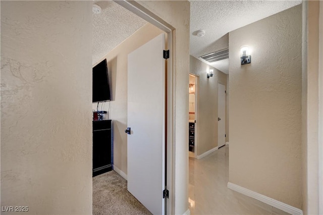 hallway with a textured ceiling