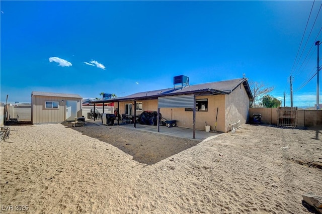 back of property with a storage shed, a patio area, and central air condition unit