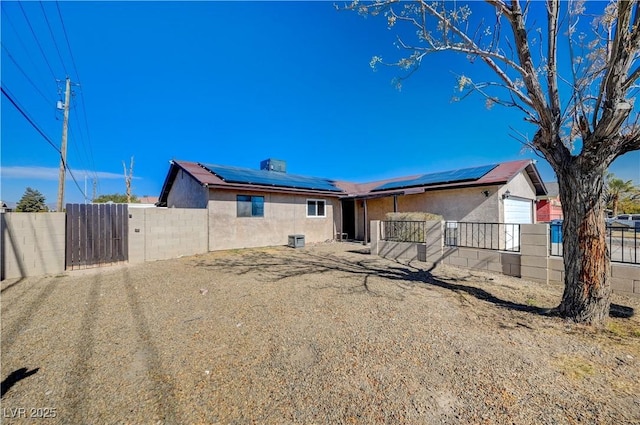 rear view of property featuring solar panels