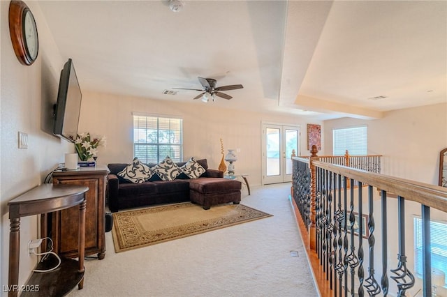 carpeted living room with beamed ceiling and plenty of natural light