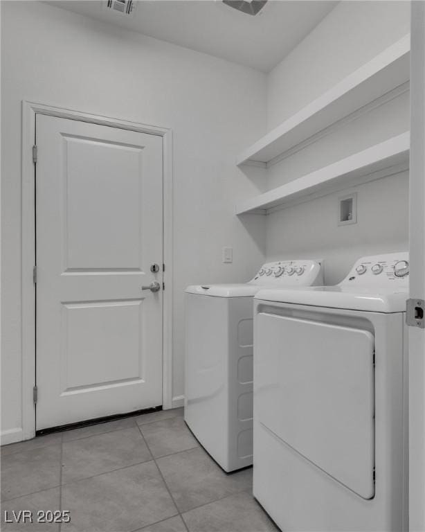 laundry room featuring light tile patterned floors and washer and dryer