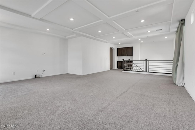 empty room featuring coffered ceiling and carpet floors