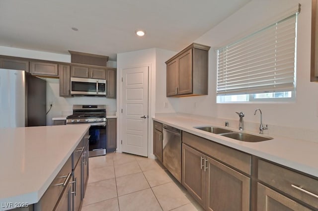 kitchen featuring stainless steel appliances, sink, and light tile patterned floors