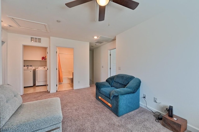 sitting room with separate washer and dryer and light carpet