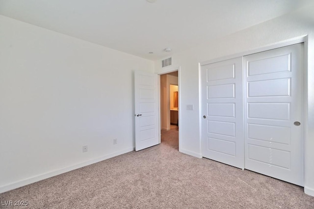 unfurnished bedroom with a closet and light carpet