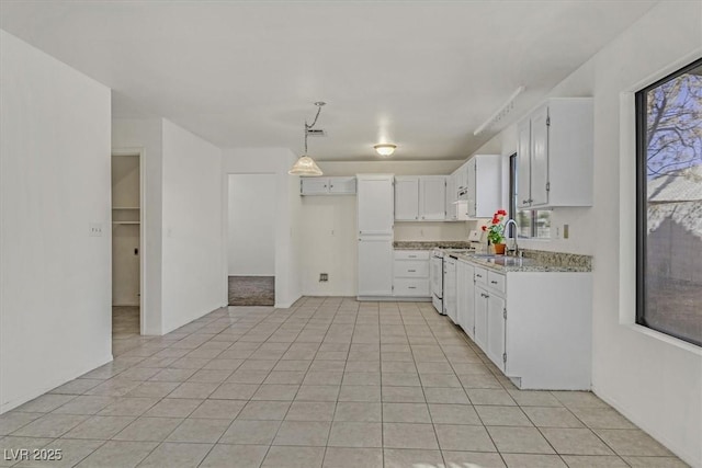 kitchen with white cabinetry, sink, hanging light fixtures, white range with gas stovetop, and light stone countertops