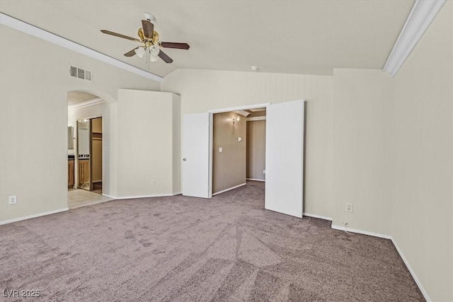 spare room featuring light carpet, vaulted ceiling, ornamental molding, and ceiling fan