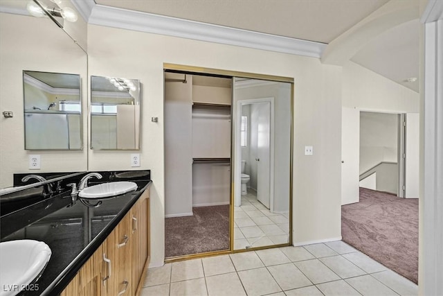 bathroom featuring vaulted ceiling, tile patterned flooring, vanity, toilet, and crown molding