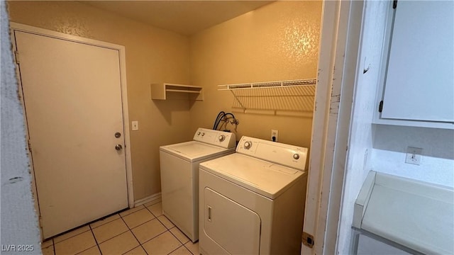 clothes washing area with washing machine and dryer and light tile patterned floors