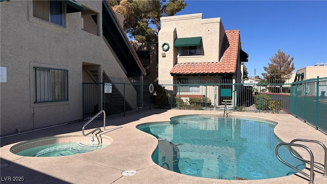 view of pool featuring a hot tub and a patio area