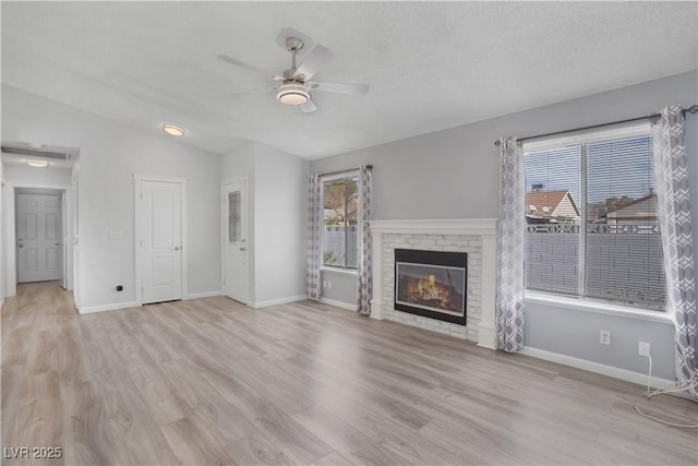 unfurnished living room with lofted ceiling, a healthy amount of sunlight, and light wood-type flooring