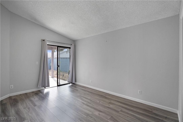 empty room featuring a water view, wood-type flooring, lofted ceiling, and a textured ceiling