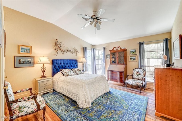 bedroom with ceiling fan, lofted ceiling, light hardwood / wood-style floors, and multiple windows