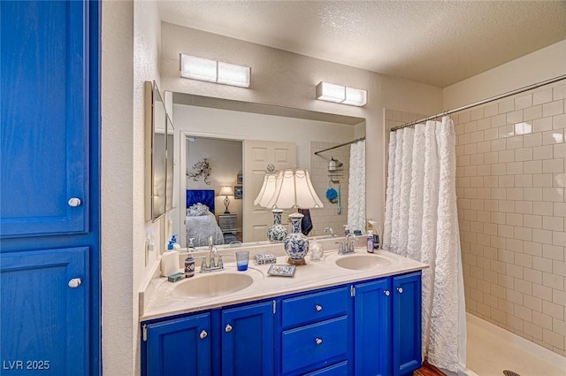 bathroom with vanity, a textured ceiling, and walk in shower