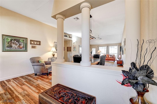 living room with decorative columns and hardwood / wood-style flooring