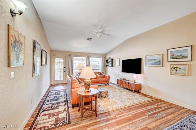 living room with hardwood / wood-style flooring, vaulted ceiling, and ceiling fan