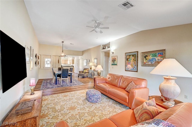 living room featuring vaulted ceiling, hardwood / wood-style floors, and ceiling fan