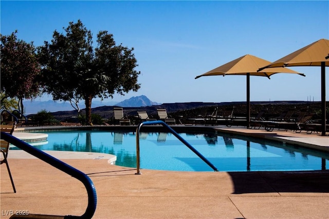 pool with a patio and a mountain view