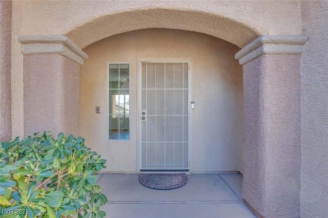 entrance to property featuring stucco siding